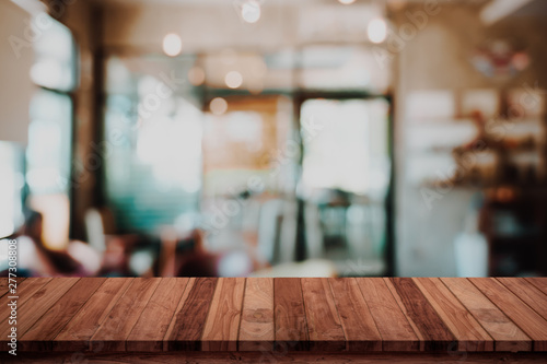 Empty wood table with blur cafe or coffee shop background.