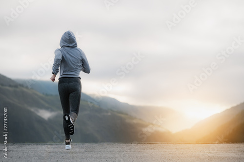 Shot of a beautiful adult woman running at sunrise.