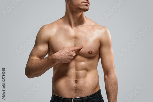 Crop guy pointing at muscular chest