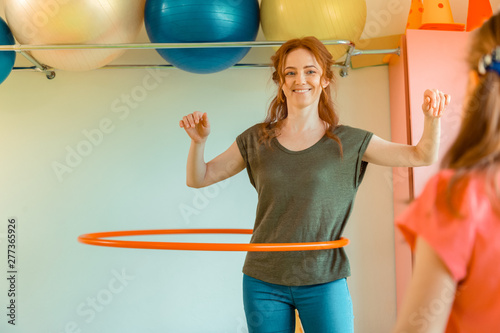 Happy positive woman rotating a hula hoop