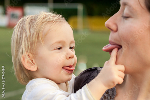 Jeune enfant et mère se tirent la langue