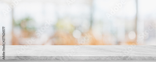 Empty white marble stone table top on blurred with bokeh cafe and restaurent interior banner background - can be used for display or montage your products