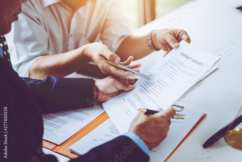 Group of middle age Asian business people and lawyers discussing and sign a contract.