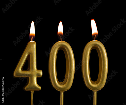 Golden birthday candles isolated on black background, number 400