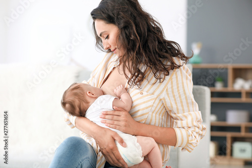 Young woman breastfeeding her baby at home