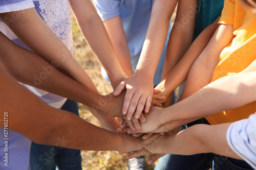 Children putting hands together outdoors