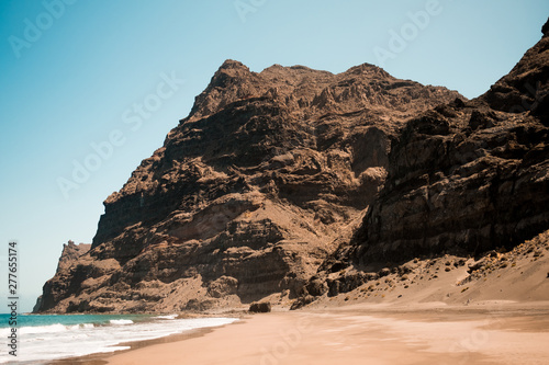 scenic view of gui gui beach in gran canaria island in spain with spectacular mountains landscape and clear blue sky and sandy beach