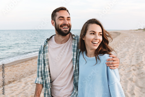 Beautiful young smiling couple spending time at the beach