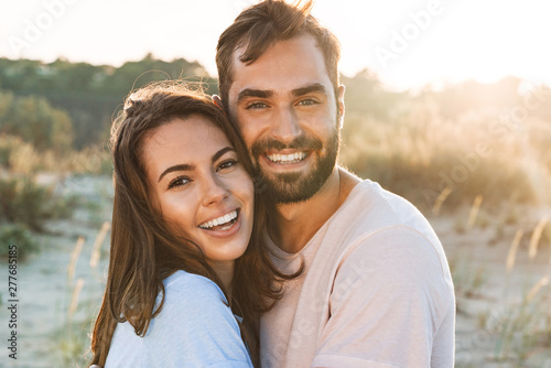 Beautiful young smiling couple spending time at the beach