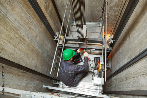 lift machinist repairing elevator in lift shaft