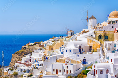 Traditional white architecture with windmills in greek picturesque Oia village on Santorini island, Greece.