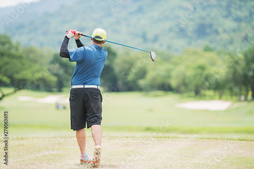 Golf player teeing off golf ball from tee box