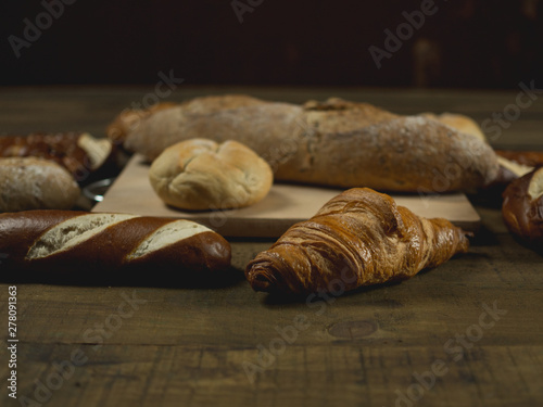 Rogalik croissant w zbliżeniu leżący na drewnianym stole