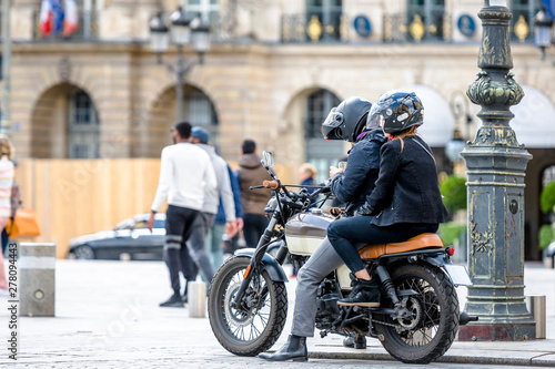 A man and a woman on a motorcycle stopped in the city square to clarify the route