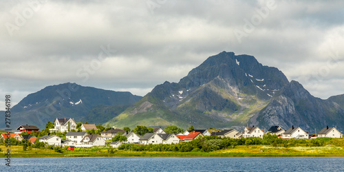 Norwegian houses and cottages at the lake with mountain in the background, Leknes, Vestvagoy Municipality, Nordland county, Norway