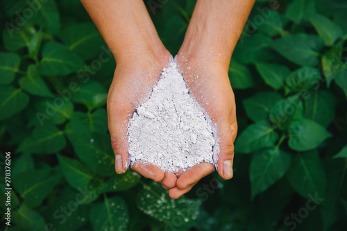 Farmer hands holding chemical organic nutrient agricultural plant fertilizer in the garden or nature