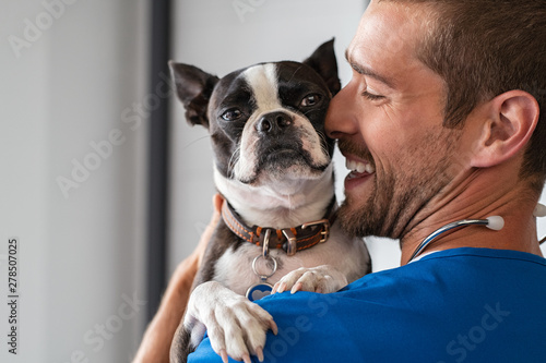 Vet cuddling pet dog