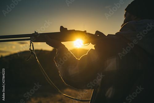 Hunter with shotgun gun on hunt. Hunter in the fall hunting season. Closed and open hunting season. Illegal Hunting Poacher in the Forest.