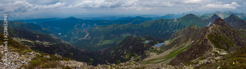 Panoramic view from Banikov peak on Western Tatra mountains or Rohace panorama. Sharp green mountains - ostry rohac, placlive and volovec with hiking trail on ridge. Summer blue sky white clouds.