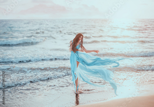 Young, slim woman with long legs dancing on the ocean