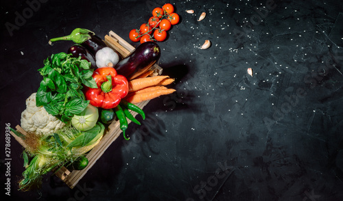 Healthy food background. Concept of healthy food, fresh vegetables in box on a dark background