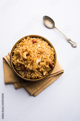 Traditional Jaggery Rice or Gur wale chawal in Hindi, served in a bowl with spoon. selective focus
