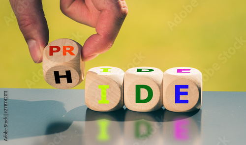 Coming out concept. Hand turns a cube and changes the word "hide" to "pride".