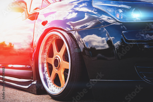 Close up of headlight and car wheel with custom disk of tuned low rider sport car