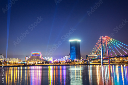 Evening and night Krasnoyarsk, panorama night city. Cable-stayed bridge in bright lights. Urban landscape.