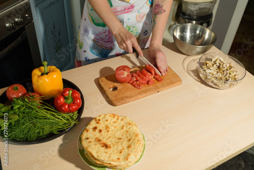 Girl cook makes cutting vegetables for tasty and juicy tortilla