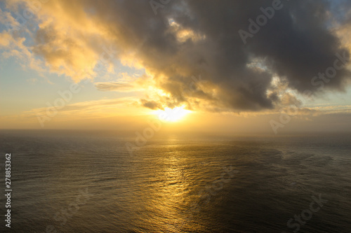Sunset over the horizon with clouds. Light reflecting off the water. New Zealand.