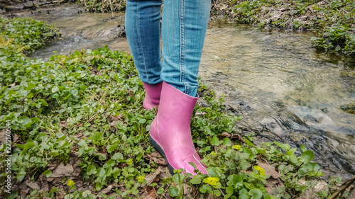 Woman in pink rubber boots on the nature on the grass
