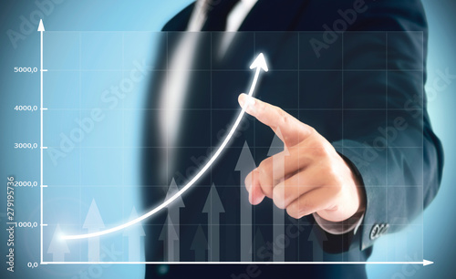 Businessman showing business growth on a chart, hands touch the graph that represents profit rises on a lot more.