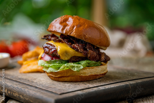 Burger with meat cheese and bacon on the board