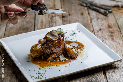 filet Mignon with truffle on white plate on wooden background