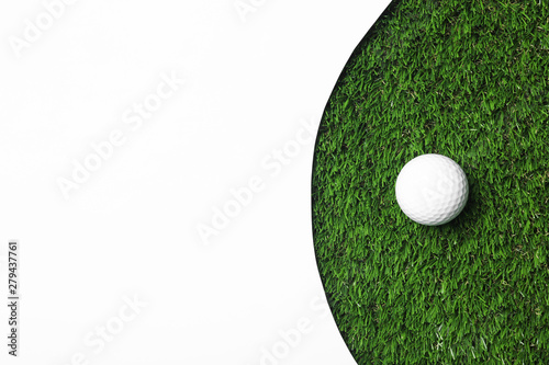Golf ball and white paper on green artificial grass, top view with space for text