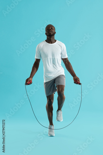 Workout. Sports man in sportswear exercising on jumping rope