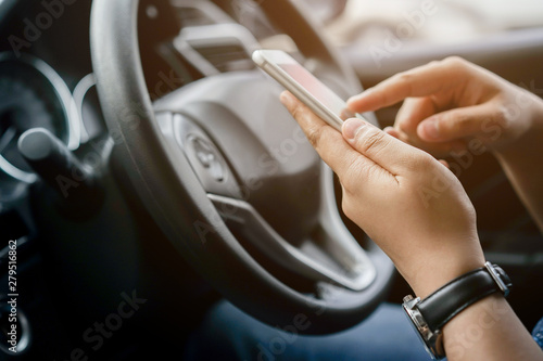 close up driver woman hand holding smartphone for using GPS navigation of travel destination and swipe for reading data on web browser or texting message online for contact while parking