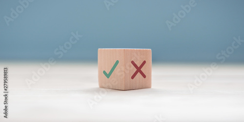 True and false symbols accept rejected for evaluation, Yes or No on wood blogs on blue background.