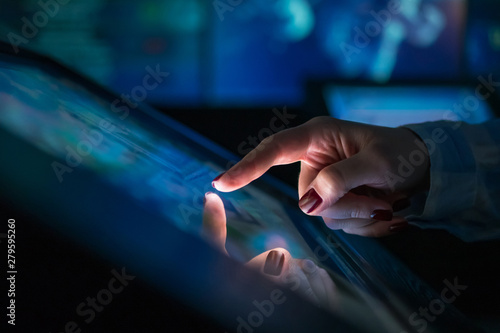 Woman using interactive touchscreen display of electronic multimedia kiosk at modern museum or exhibition. Education, learning and technology concept