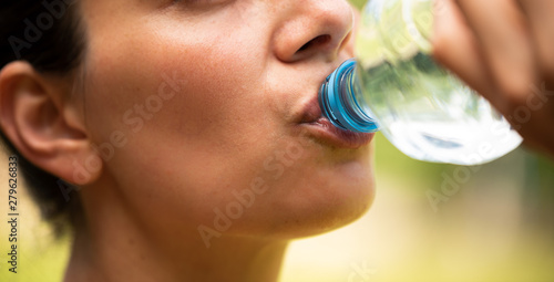 Frau trinkt Wasser aus Plastikflasche