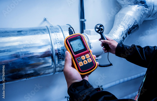 Technician use hand-held anemometer measuring air flowing measurement, wind speed and pressure.