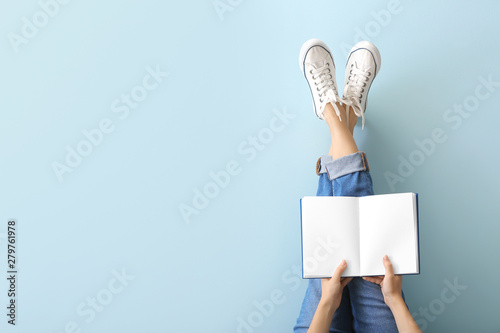 Woman with book on color background