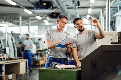 Industrial workers doing quality control of manufactured products in a factory.