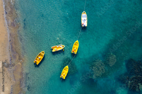 Aerial view of boats floating on calm sea water. Turquoise ocean seen from above.