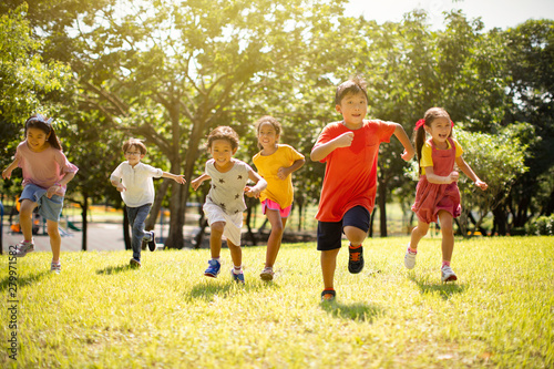 Multi-ethnic group of school children laughing and running