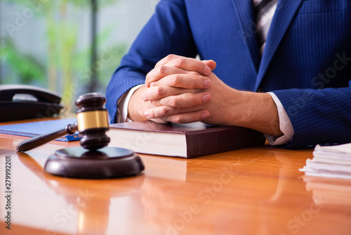 Young male judge sitting in courtroom