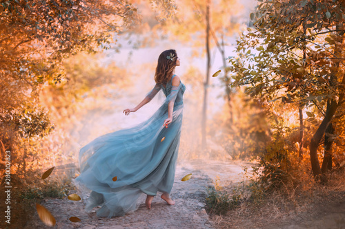 delightful light girl in sky blue turquoise dress with long flying train, princess of wind and daughter of storm, lady with dark hair throws fallen leaves to ground, autumn story in art processing.