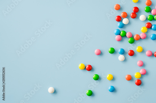 Background of chocolate candy with colored glaze. Scattered multicolored candy.