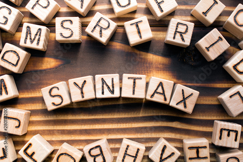 syntax composed of wooden cubes with letters, grammatical arrangement of words in a sentence concept, the random letters around, top view on wooden background